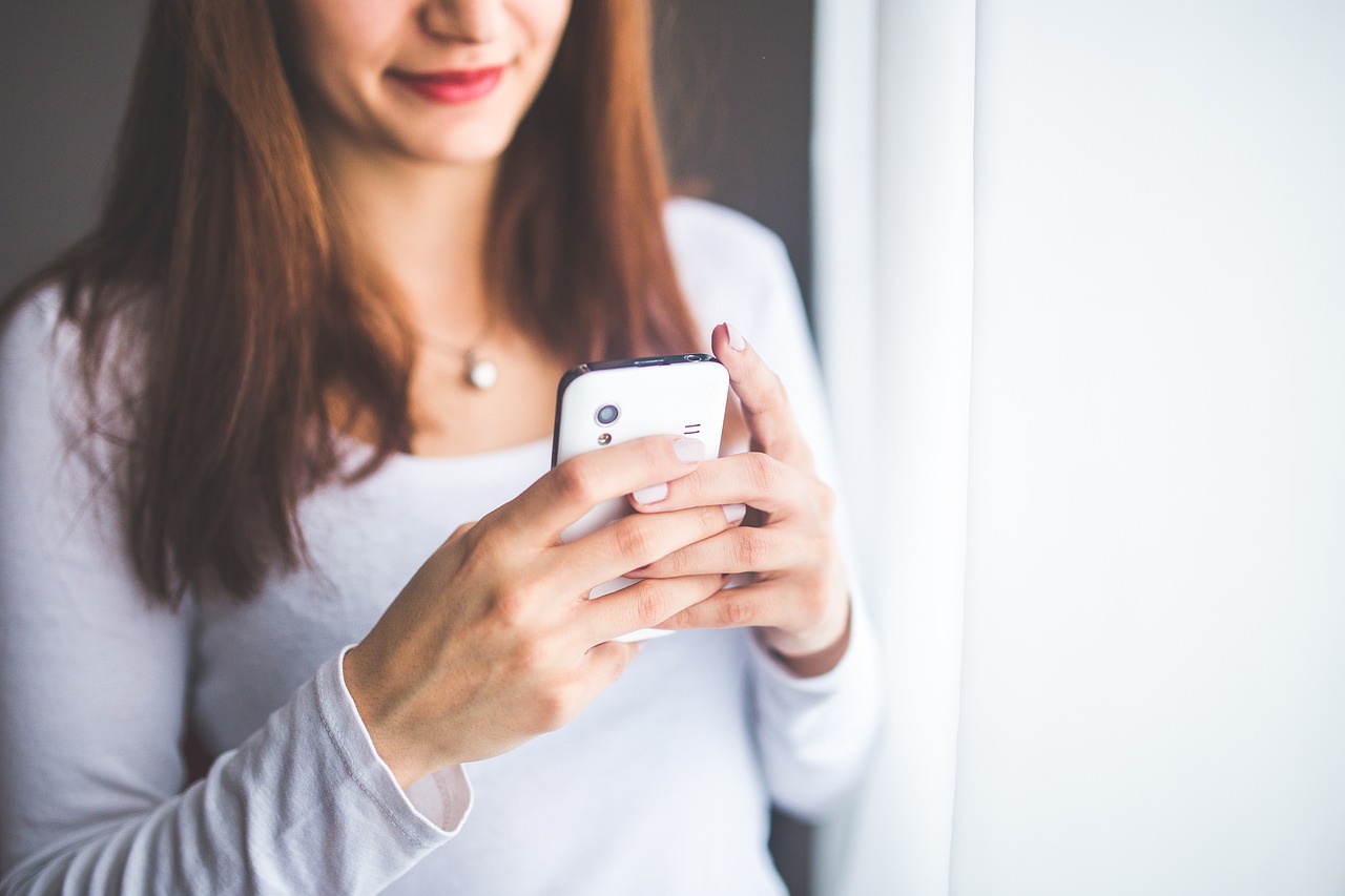 Women looking at her phone and needing to get her cell phone repaired